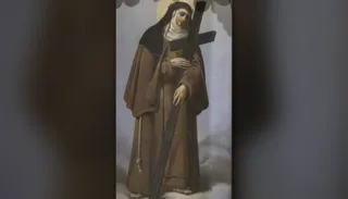 Santa Veronica Giuliani in abito cappuccino, coronata di spine, porta una grande croce di legno
